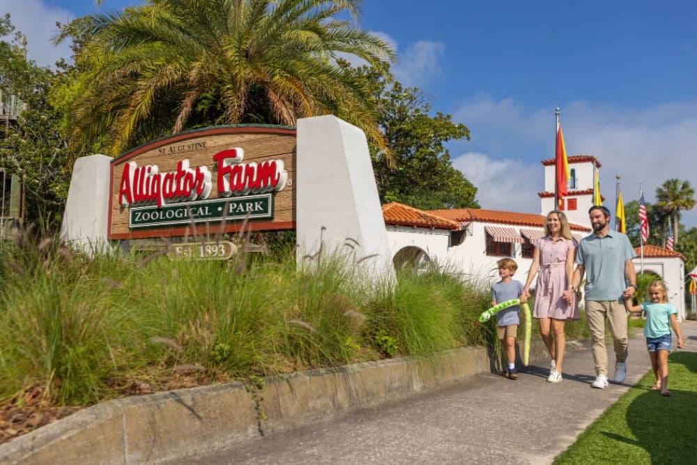A family walks past the entrance sign of Alligator Farm Zoological Park in St. Augustine.
