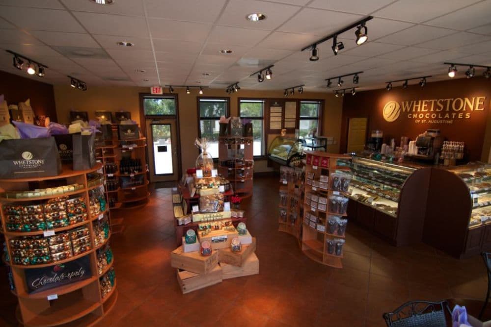 A cozy chocolate shop interior featuring displays of various chocolate products and a welcoming atmosphere.
