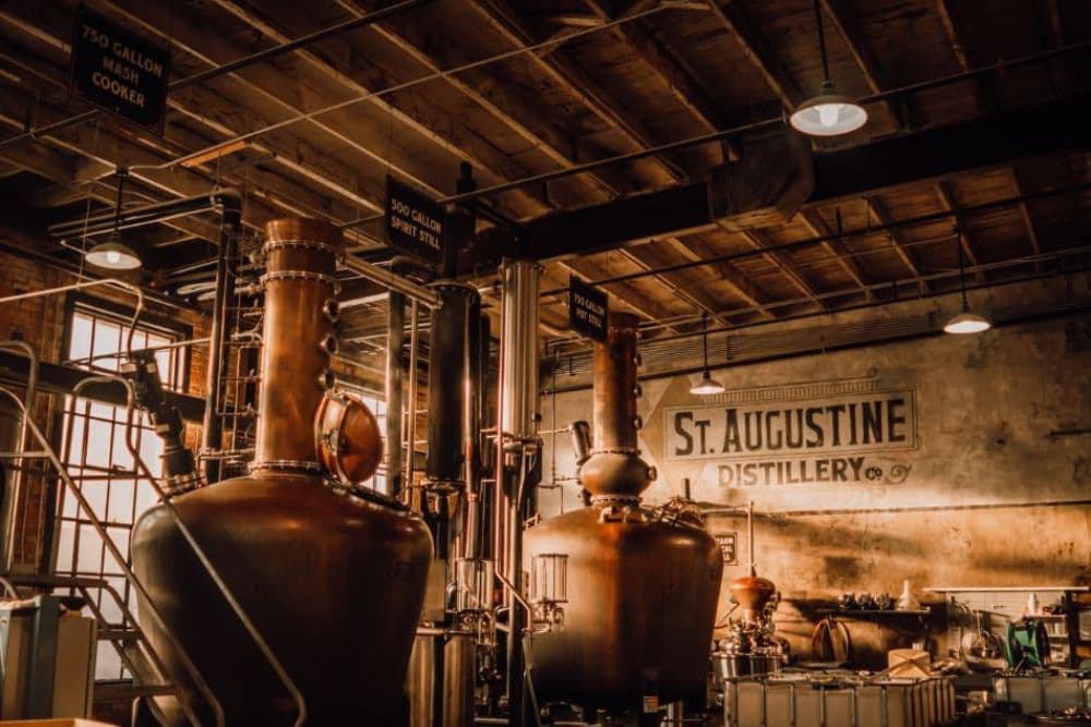 Interior of St. Augustine Distillery showcasing large copper stills and brewing equipment.
