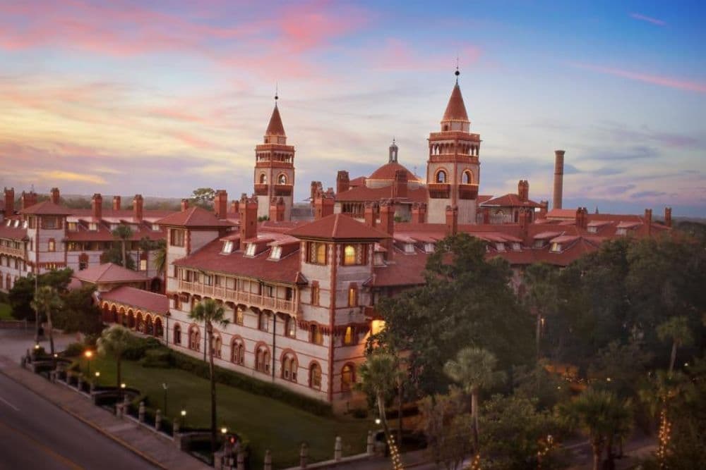 Historic building with red-tiled roofs set against a colorful sunset sky.
