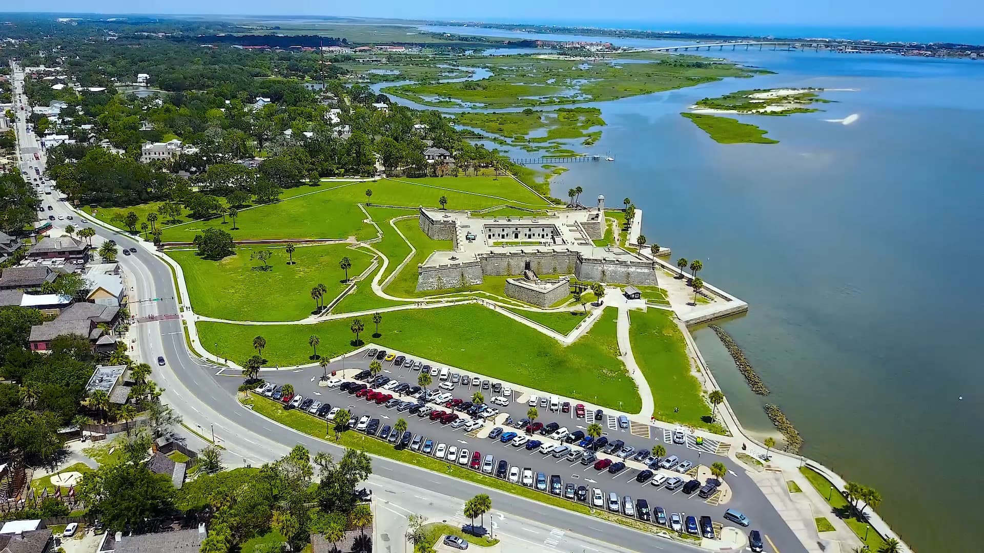 Aerial view of old fort surrounded by green grass and large body of water Aerial view of old fort surrounded by green grass and large body of water